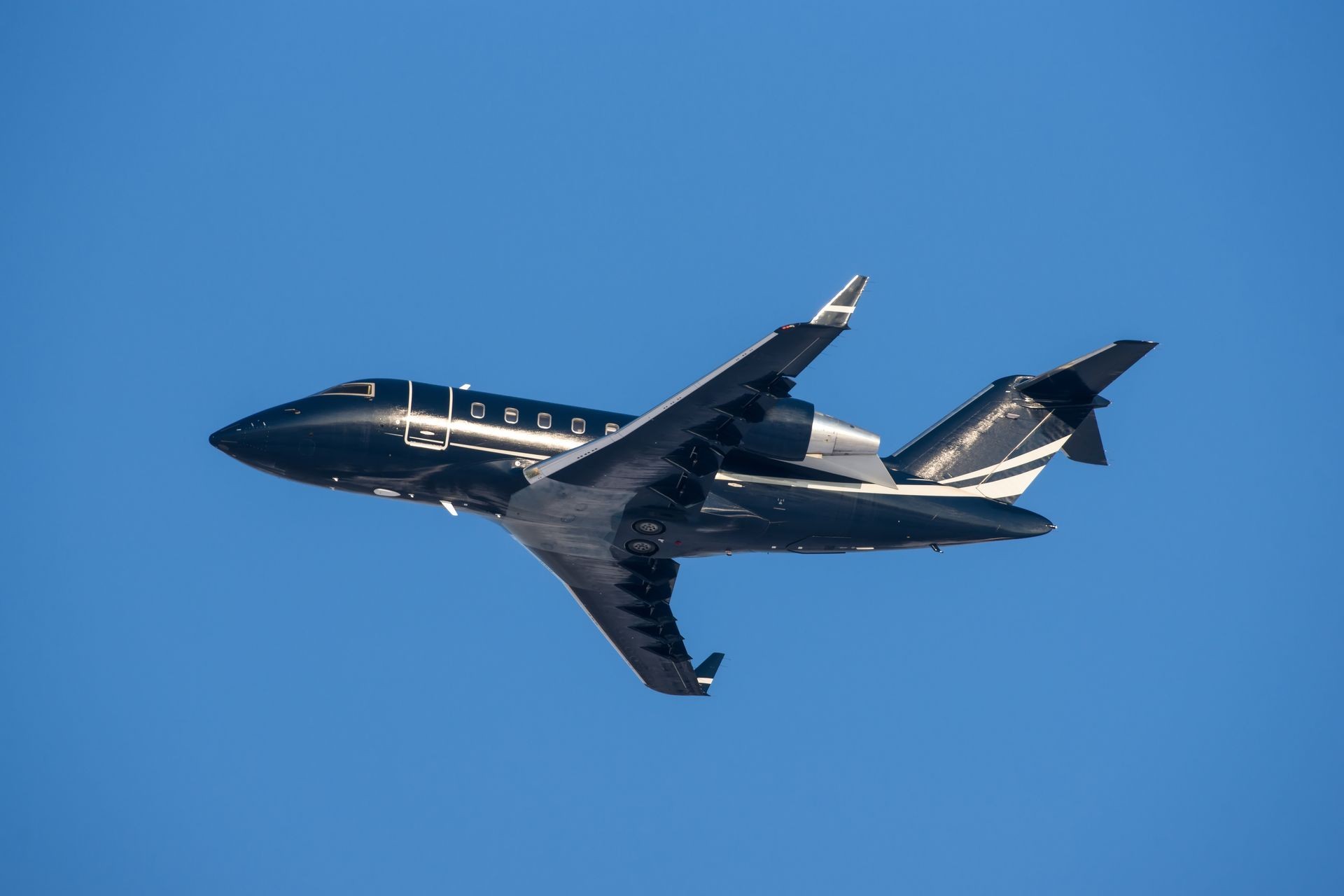 Small black modern private jet taking off to the sky